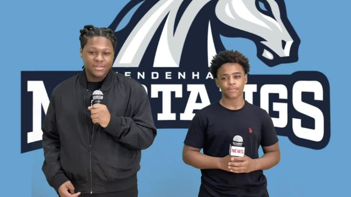 Two Mendenhall Middle Students hold microphones while delivering school news