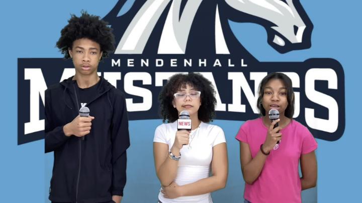Three Mendenhall Middle students hold microphones while delivering their school news